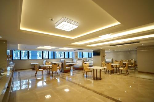 a restaurant with tables and chairs in a building at Vienna International Hotel - Shanghai Pudong Airport Free Trade Zone in Shanghai