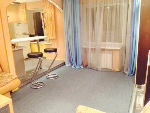 a room with two stools in front of a window at Apartment on Druzhby 4 in Perm