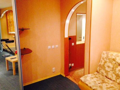 a room with a mirror and a chair in a room at Apartment on Druzhby 4 in Perm
