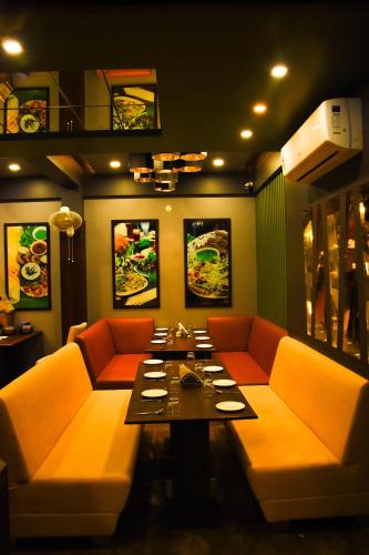 a dining room with a table and orange chairs at Hotel Shyam Palace in Bhuj