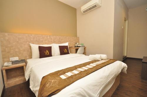 a bedroom with a large bed in a room at Art Cottage Hotel in Ipoh