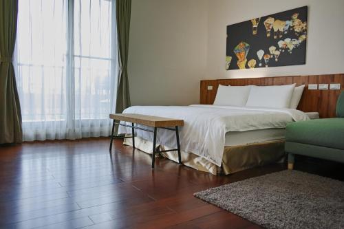1 dormitorio con cama, mesa y sofá en I Like B&B, en Taitung