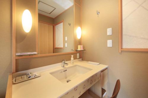 a bathroom with a sink and a mirror at Hotel Okada in Hakone