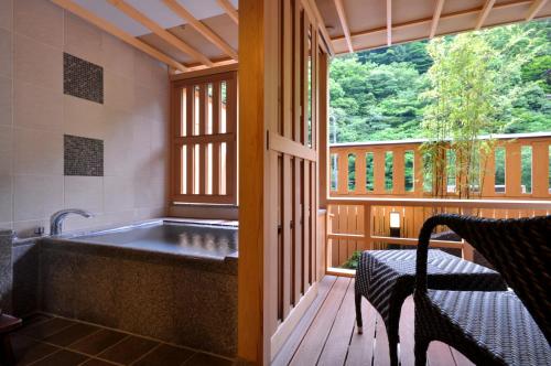 a bath tub in a room with a window at Hotel Okada in Hakone