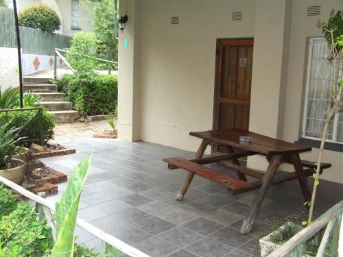 a wooden picnic table sitting outside of a house at Old Coach Road Guest House in Barberton