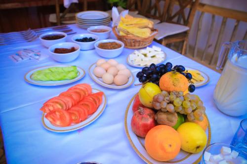 a table with plates of fruits and vegetables on it at Evim Otel in Zaqatala