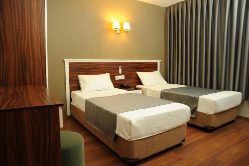 Een bed of bedden in een kamer bij Deniz Palace Hotel