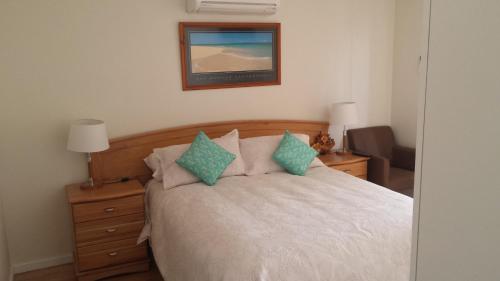 a bedroom with a bed and a picture on the wall at Alexander Drive B & B in Esperance