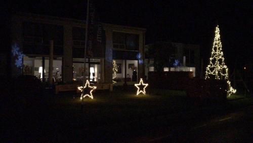 a christmas tree and lights in front of a building at De Slaapfabriek vakantiehuis en trainingslocatie in Teuge