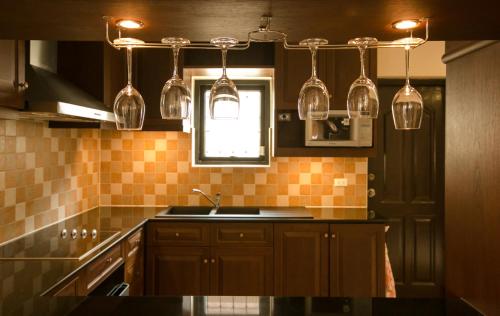 a kitchen with glasses hanging over a sink at Royal Pool Villa Pattaya in Nong Prue
