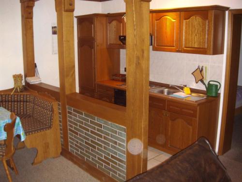 eine Küche mit Holzschränken und einer Spüle in der Unterkunft Ferienwohnungen Seidenweber in Schmallenberg