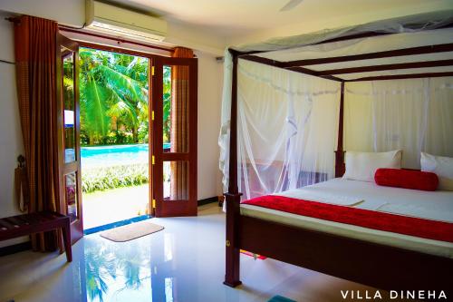 a bedroom with a bed and a sliding glass door at Villa Dineha in Hikkaduwa