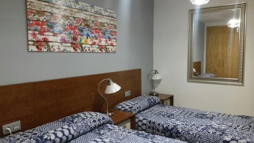 Habitación de hotel con 2 camas y espejo en Pleta del Mon en Benasque