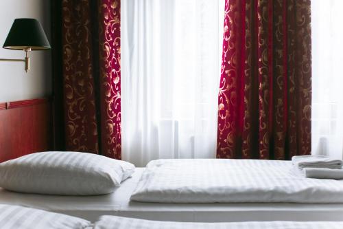 two pillows on a bed in front of a window at Merite Hotels Hamburg Altona GmbH in Hamburg