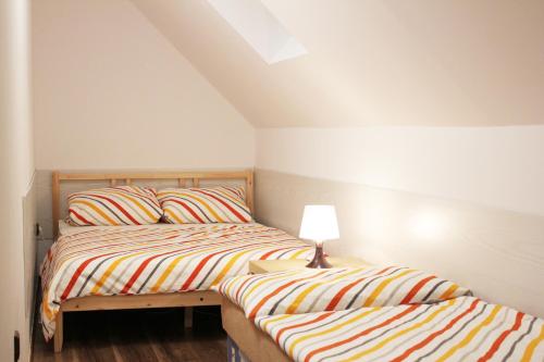 two beds in a small bedroom with a lamp at Apartmá Království Beskyd in Horní Bečva