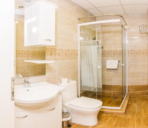 a bathroom with a shower and a toilet and a sink at Centric Lifestyle Apartments in Budapest