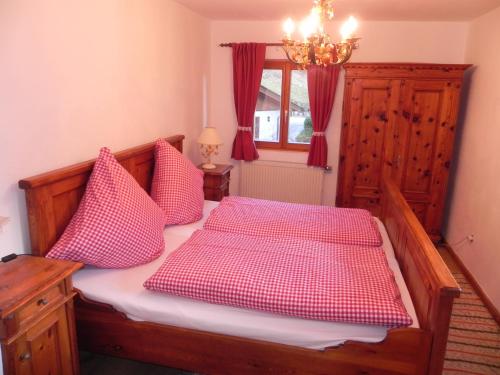 Schlafzimmer mit einem Bett mit roten und weißen Kissen in der Unterkunft Haus am See in Ramsau bei Berchtesgaden