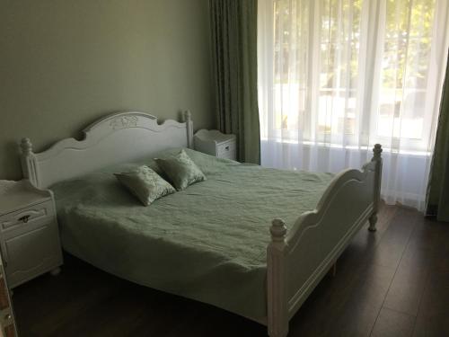 ein Schlafzimmer mit einem weißen Bett und einem Fenster in der Unterkunft Purple Amber in Juodkrantė
