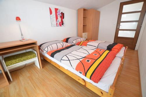 1 dormitorio con 2 camas individuales y escritorio en Apartma Štastný, en Bechyně