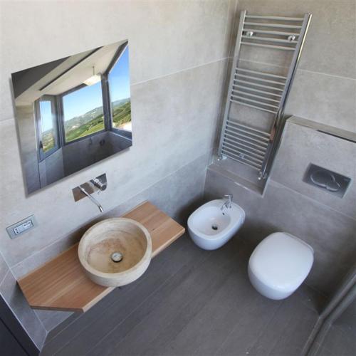 a bathroom with a sink and a toilet and a mirror at Casa Sobrero in Castiglione Falletto