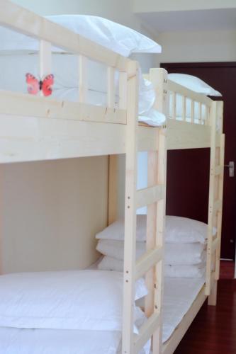 two white bunk beds with a butterfly sitting on them at Lan House Youth Apartment in Guangzhou