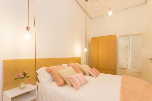 a bedroom with a large white bed with pink pillows at Mirador del Arriaga in Bilbao