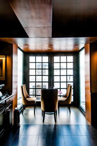a dining room with a table and chairs and windows at The Vintage Gulmarg in Gulmarg