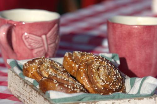 three donuts on a plate on a table with two cups at Sydkustens at Pillehill in Skivarp