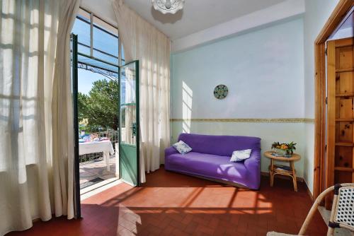 a purple couch in a living room with a window at B&B Iris in Conca dei Marini