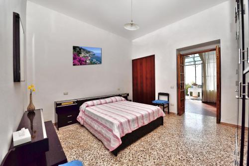 a bedroom with a bed and a desk and a window at B&B Iris in Conca dei Marini