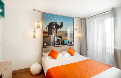 a bedroom with a bed with orange pillows at Hôtel Mayet in Paris