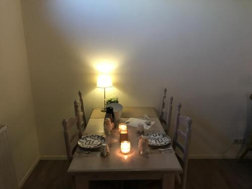 a dining room table with a lamp and candles on it at De Beddestee in Ruinen