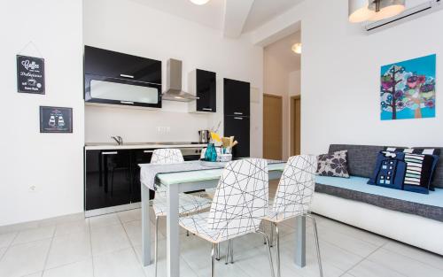 a kitchen and dining room with a table and chairs at Apartments Matea in Baška