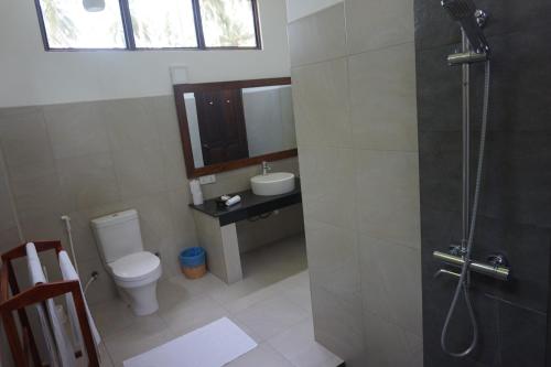 a bathroom with a toilet and a sink and a shower at Lanka Beach Boutique Bungalows & Grand Villa in Tangalle