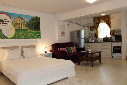 Cet appartement comprend une chambre avec un lit blanc et une cuisine. dans l'établissement Airport Residence 2, à Otopeni