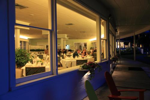 un restaurante con gente sentada en las mesas de la ventana en Basin Harbor, en Vergennes