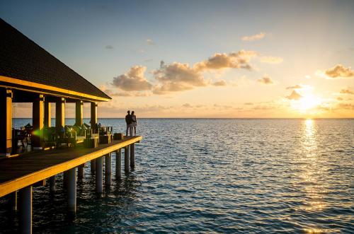 two people standing on a pier over the water at Summer Island Maldives in North Male Atoll