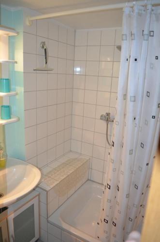 y baño con bañera, lavamanos y ducha. en Ferienwohnung Pusteblume en Wildemann