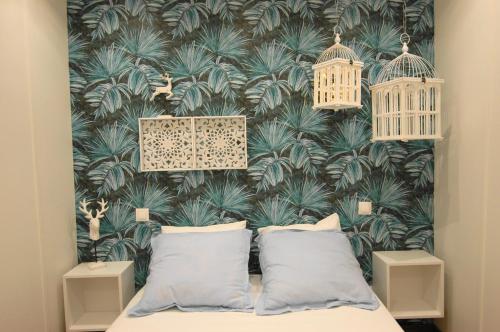 a bedroom with a birdcage wallpaper and a bed with pillows at Apto El Clavo-CON PARKING GRATIS in Toledo