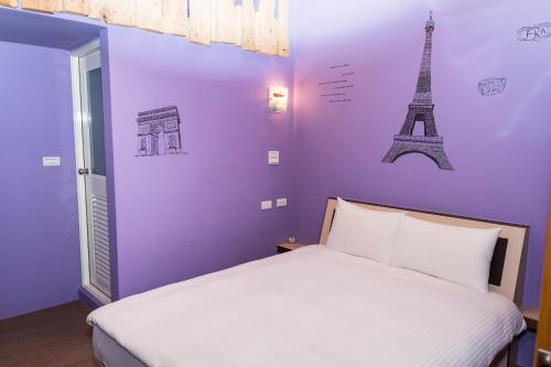 een slaapkamer met een bed en de eiffeltoren bij Clover B&B in Yuchi