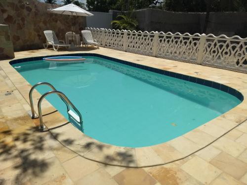a blue swimming pool with a rail fence around it at Pousada Santa Fé in Porto De Galinhas