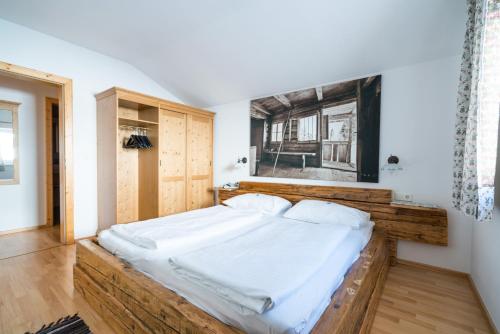 オーバータウエルンにあるHaus Petergstammのベッドルーム1室(大型ベッド1台、木製ヘッドボード付)