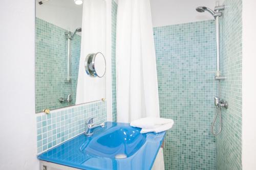 a bathroom with a blue sink and a shower at Tres Pins in Colonia de Sant Pere