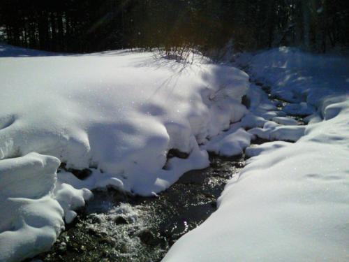 a pile of snow on the side of a river at Appartement Haus Zalim in Brand