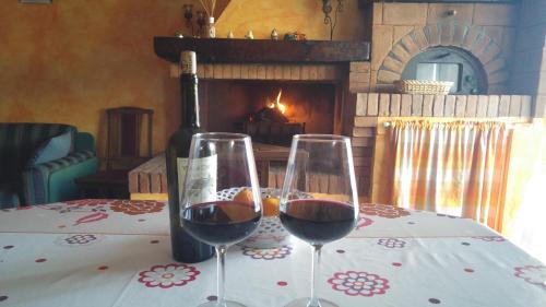 two glasses of wine on a table with a fireplace at River House in Fiumicino