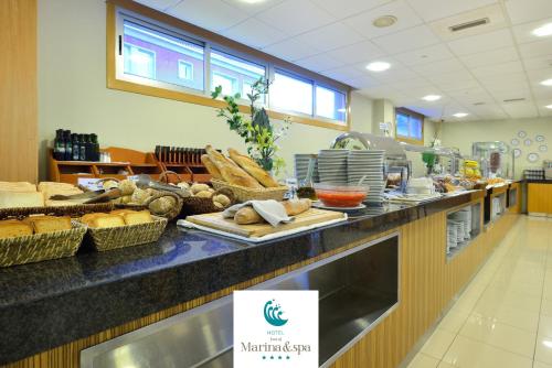 a cafeteria with a counter with bread and other foods at Hotel Norat Marina & Spa 4* Superior in O Grove