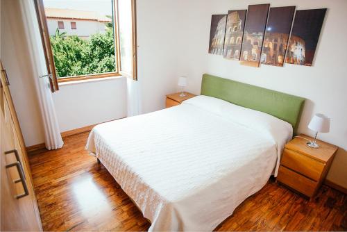 ein Schlafzimmer mit einem weißen Bett und einem Fenster in der Unterkunft Domus Leonardo-Private Free Parking in Fiumicino