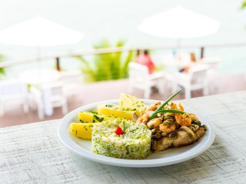 a plate of food with shrimp and rice on a table at Barra do Piuva Porto Hotel in Ilhabela