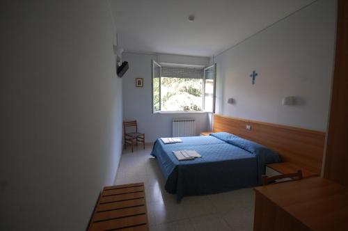 a bedroom with a blue bed and a window at Casa Religiosa Di Ospitalità Nazareno in Spoleto