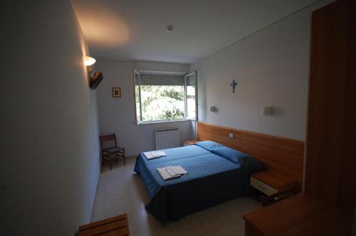a bedroom with a blue bed and a window at Casa Religiosa Di Ospitalità Nazareno in Spoleto